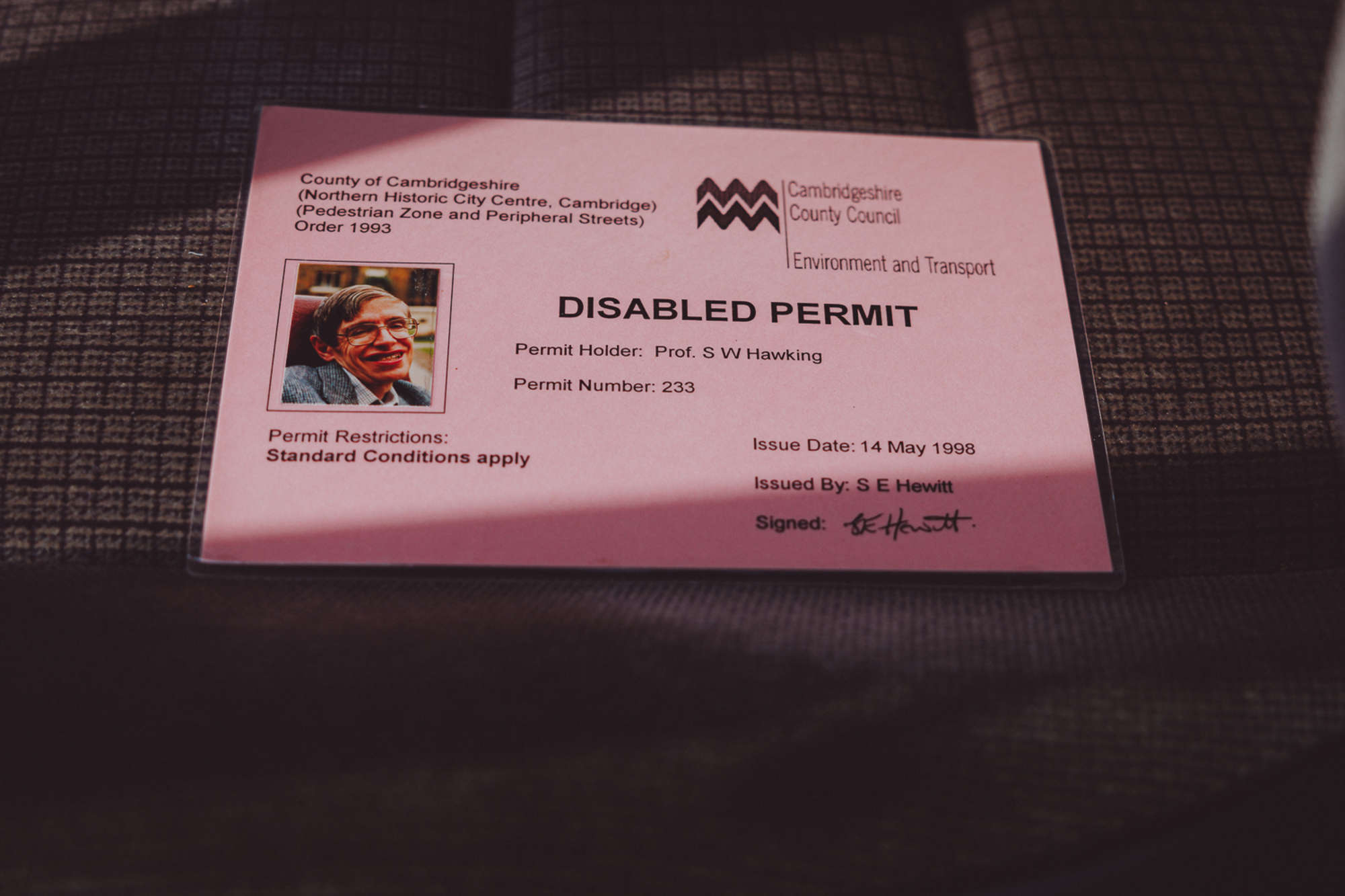 INCREDIBLE pictures show Stephen Hawking’s minivan and disabled parking permit in front of Hawking’s College at Cambridge - which are now up for sale.